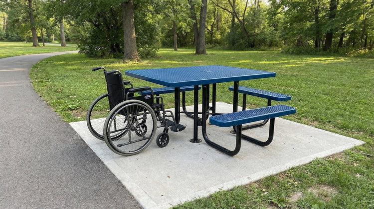ADA-accessible commercial picnic table on concrete pad in public park with wheelchair access