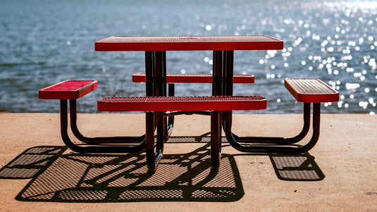 Commercial Grade red picnic table by a lake on a sunny day
