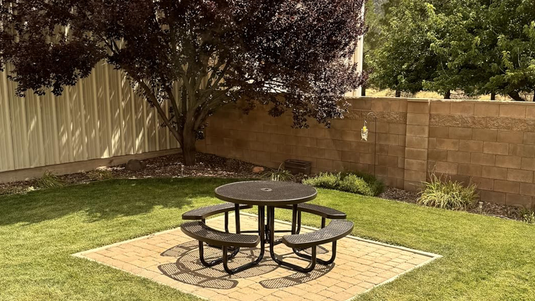 a brown round table in a backyard