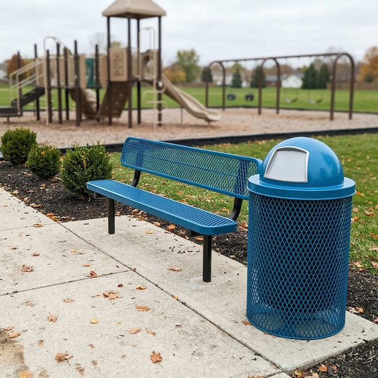 Blue bench and trash can next to a playground