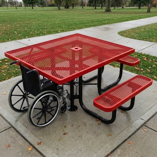 Red metal picnic table with wheelchair accessibility features on a sidewalk.
